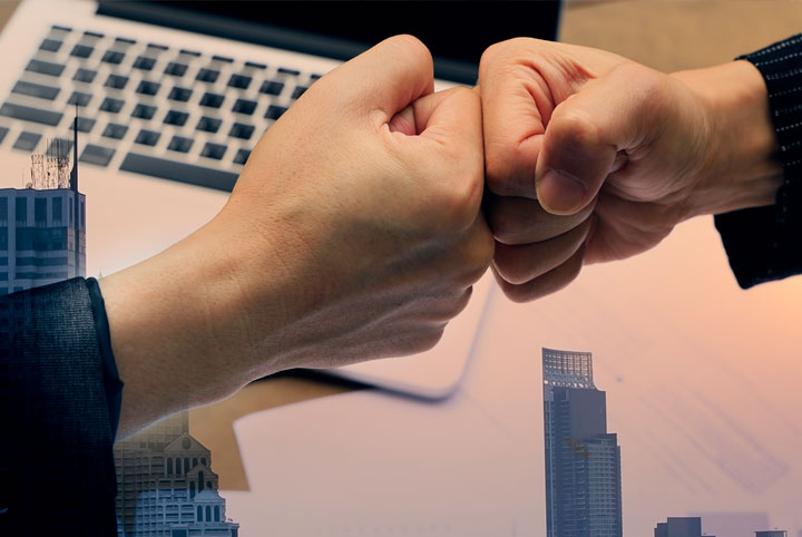 Dwie rece na tle komputera, w tle architektura